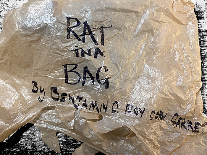 A bag with the text "Rat in a bag" written on it. By Benjamin C. Roy Cory Garrett
